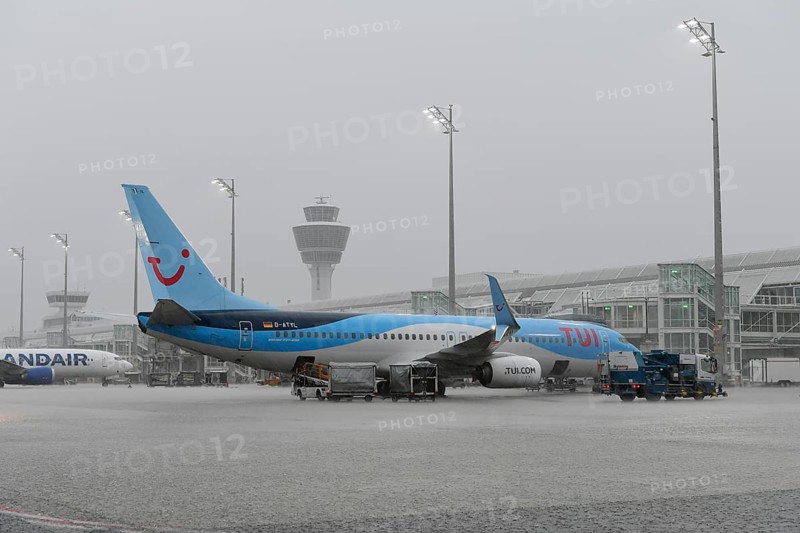 Tui fly Boeing B737-800 on handling position during heavy rain, thunderstorm, rain cloud, storm, with Iceland Air, Terminal 1, Munich Airport, Upper Bavaria, Bavaria, Germany, Europe