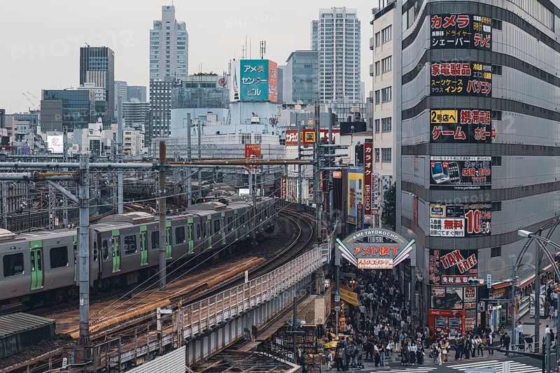 Moving train on the railway tracks next to the Ameyoko shopping street during the day in the Ueno neighbourhood in the Taito district of Tokyo city in Japan