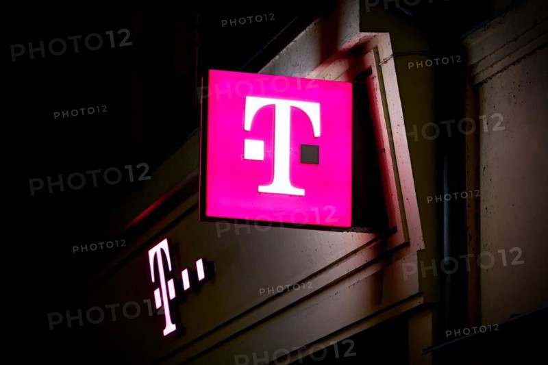 Illuminated sign at a Telekom shop in the city centre of Karlovy Vary in the Czech Republic at night
