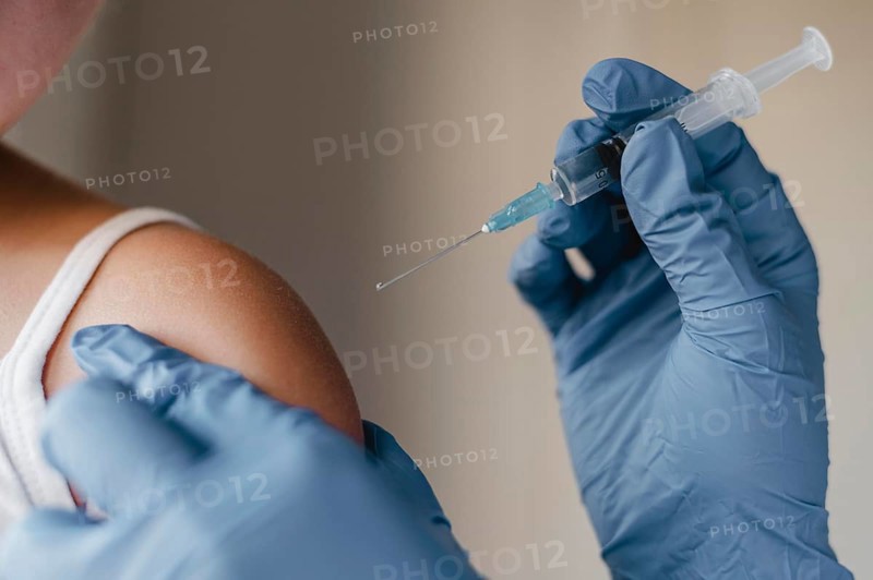 Doctor with gloves administering little child vaccine