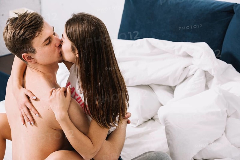 Young couple kissing bed