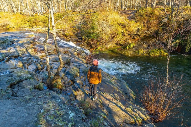 Hiker admiring zaldibartxo waterfall in gorbeia natural park, basque country, a beautiful nature landscape in northern spain