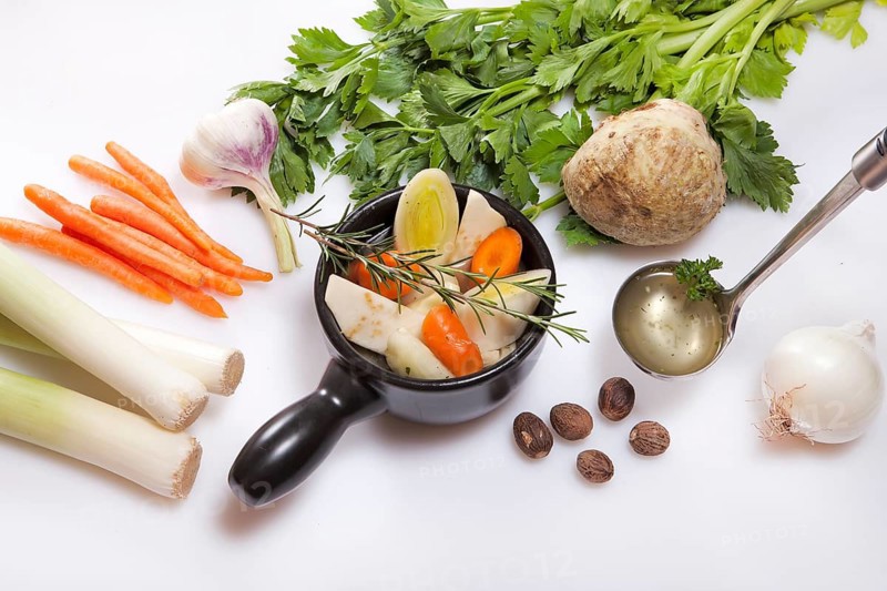 Ingredients for fresh vegetarian vegetable stock, leek, carrots, garlic, celery, onions, nutmeg, rosemary, vegetable stock, soup cup, carrots, celery, soup ladle