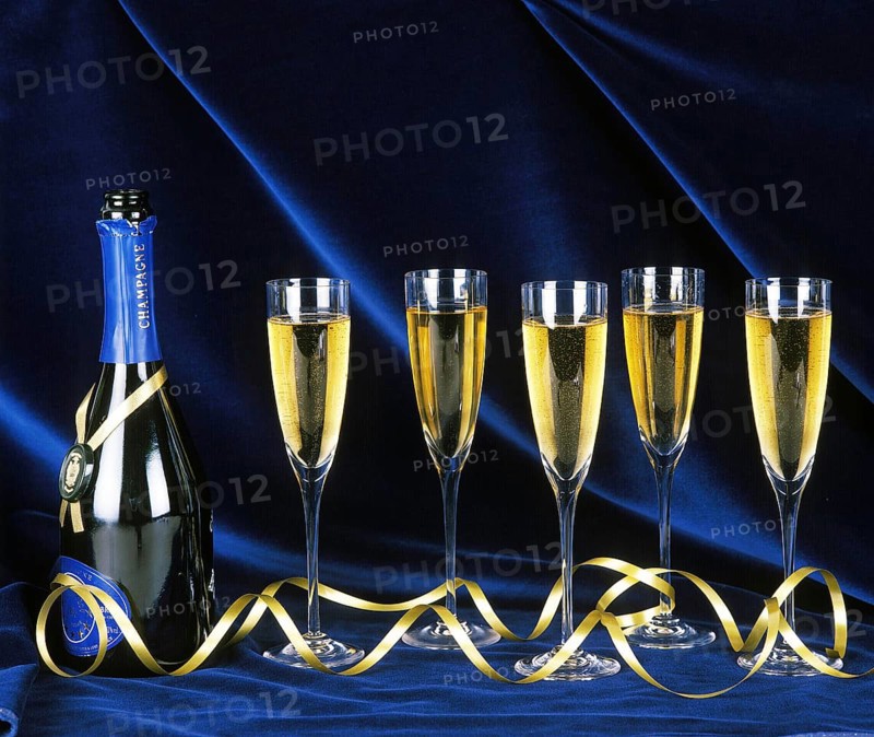 Bottle and Glasses of Champagne against Blue Background