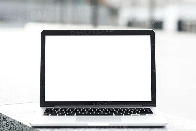 Open laptop showing blank white screen display bench against blurred background. High resolution photo