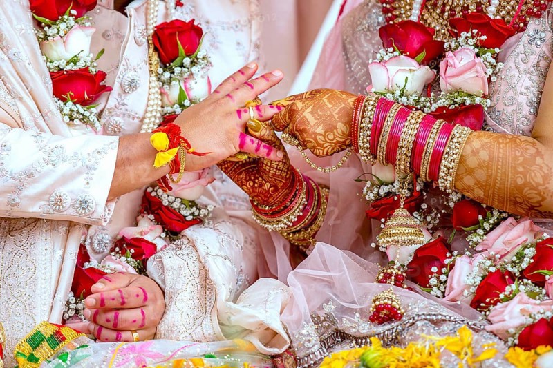 Indian bride passing wedding ring on her grooms finger on her wedding ceremony, Mauritius, Africa