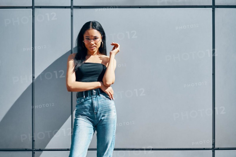 Stylish trendy african american woman posing on street wall urban background with copy space