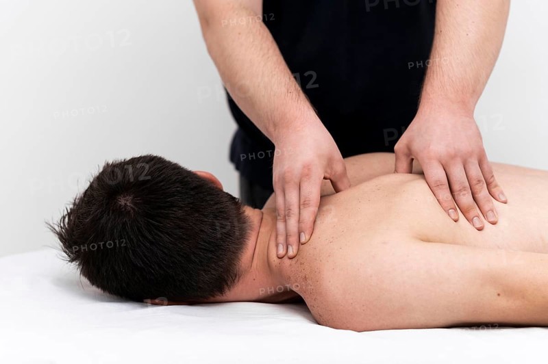 Man being given back massage by physiotherapist