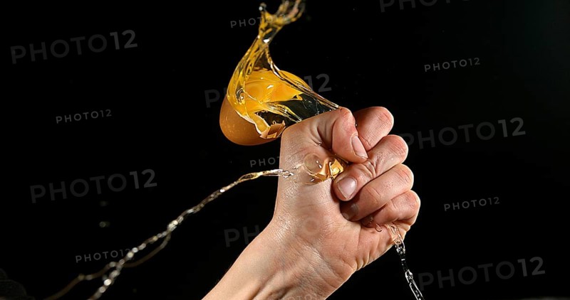 Hand of woman with a Chicken Egg against Black Background