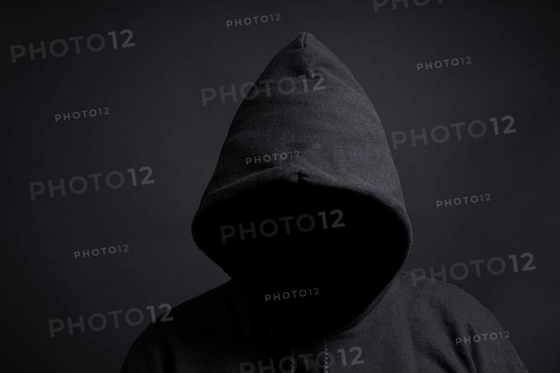 faceless person wearing black hoodie hiding face in shadow