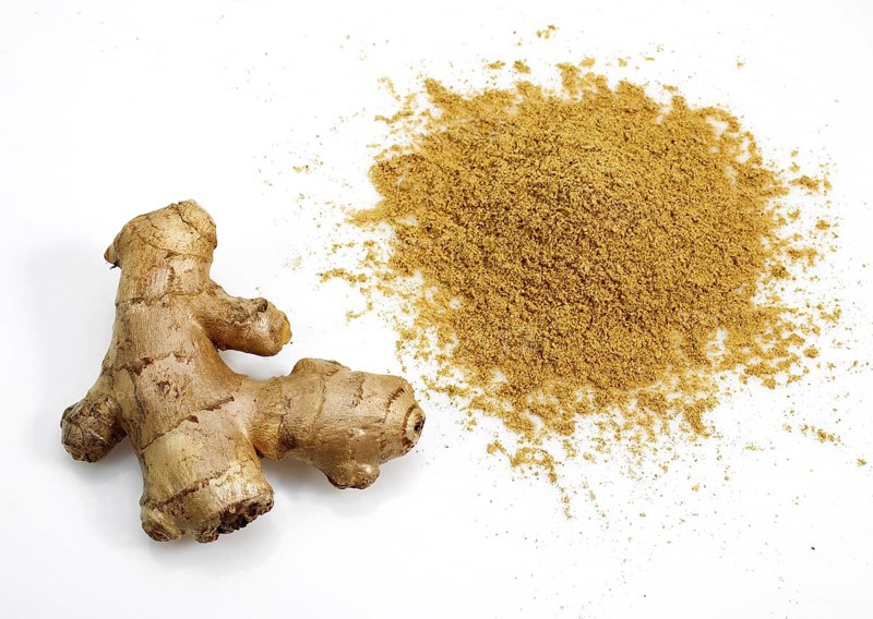 Ginger (zingiber officinale) Powder and Root against White Background