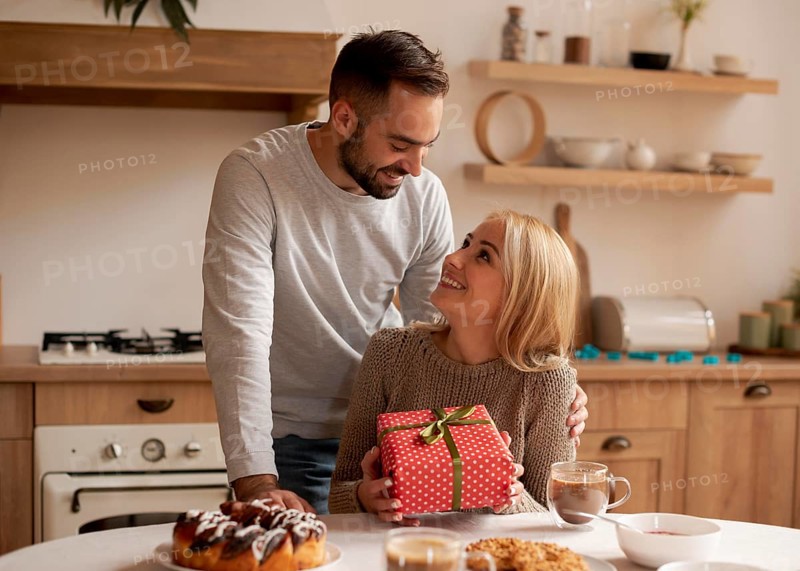 Man surprising woman with present