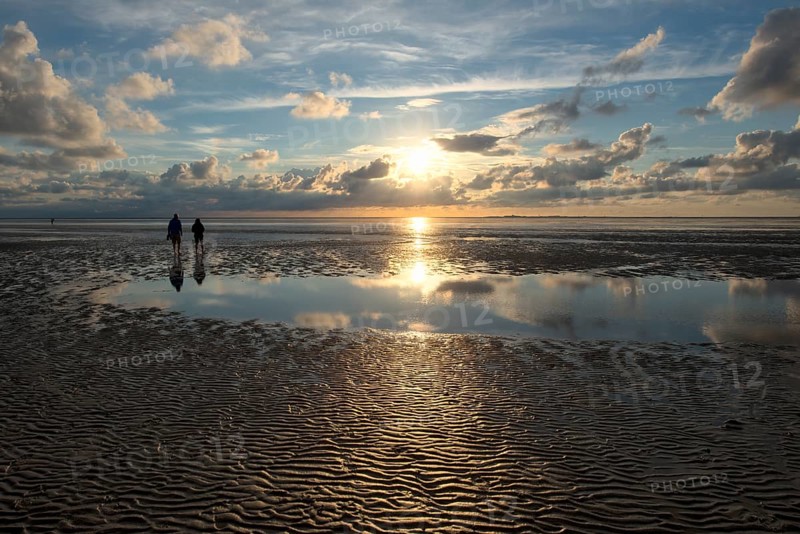 Evening atmosphere, Wadden Sea, people walking at sunset, Neuwerk Island behind, Hamburg Wadden Sea National Park, Cuxhaven, Lower Saxony, Germany, Europe