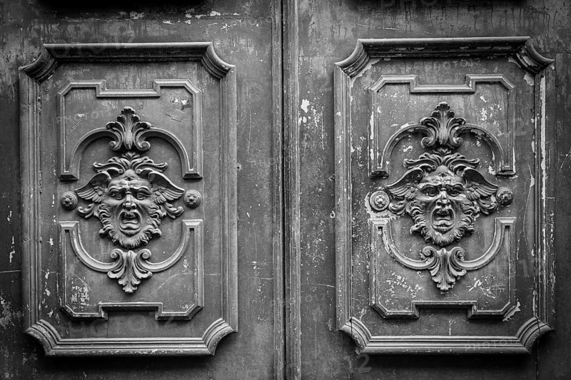Gothic mask on an old wodden door in Milan - Italy