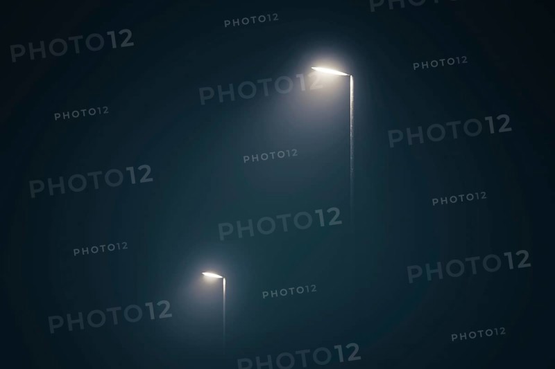 Street lights in the misty evening glowing in the dark by midnight