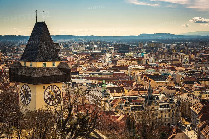 Graz, Austria, 10.03.2020: Uhrturm landmark in Graz cityscape view, Styria region of Austria. Clocktower against cityscape, Europe