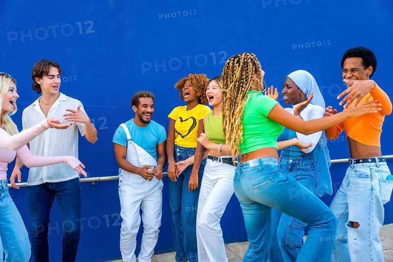 Group of young people dancing together outdoors in a multicultural party