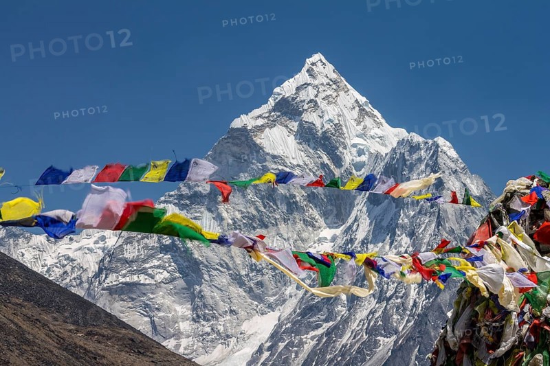 Ama Dablam, the well-known mountaineering peak in the Everest Region, seen with Buddhist prayer flags, waving in the wind at Thokla Pass, en-route to the Everest Base Camp. Khumbu, the Himalayas. Sagarmatha National Park, the UNESCO World Heritage Site. Solukhumbu, Nepal, Asia