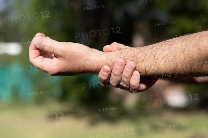 Close-up of man massaging his wrist