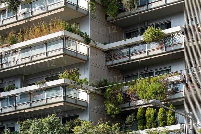 Barcelona's Eco-Friendly Marvel: Multilevel apartment building adorned with lush balconies, a green facade symbolizing sustainability in the heart of the city