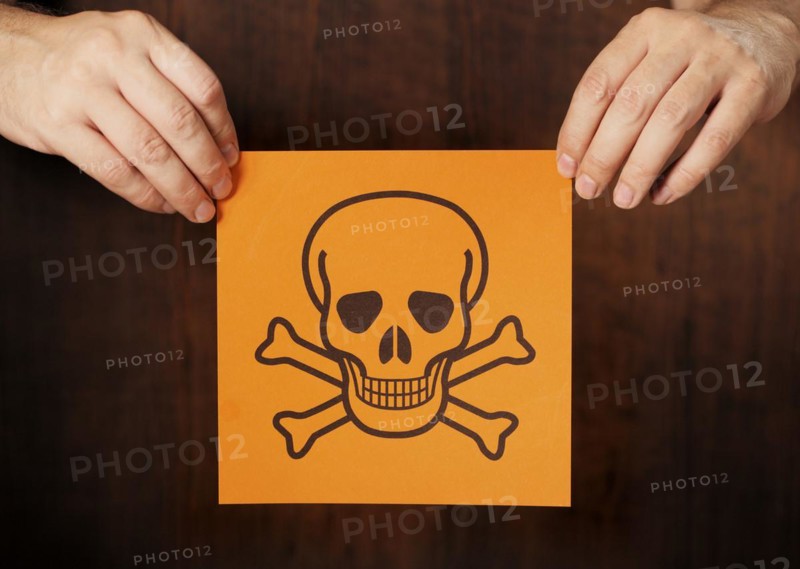 Man holding a warning sign for poison