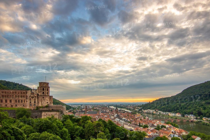 View over an old town with castle or palace rune in the evening at sunset. This town lies in a river valley of the Neckar, surrounded by hills. Heidelberg, Baden-Württemberg, Germany, Europe