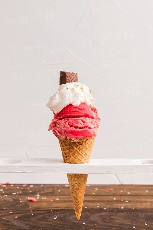 Red frozen ice scoop with with whipped cream chocolate cone