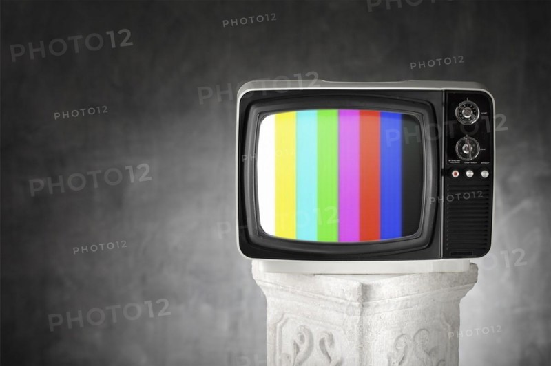 Old television with color bars on a plaster column