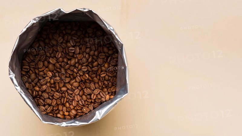 Black coffee beans beige background with copy space