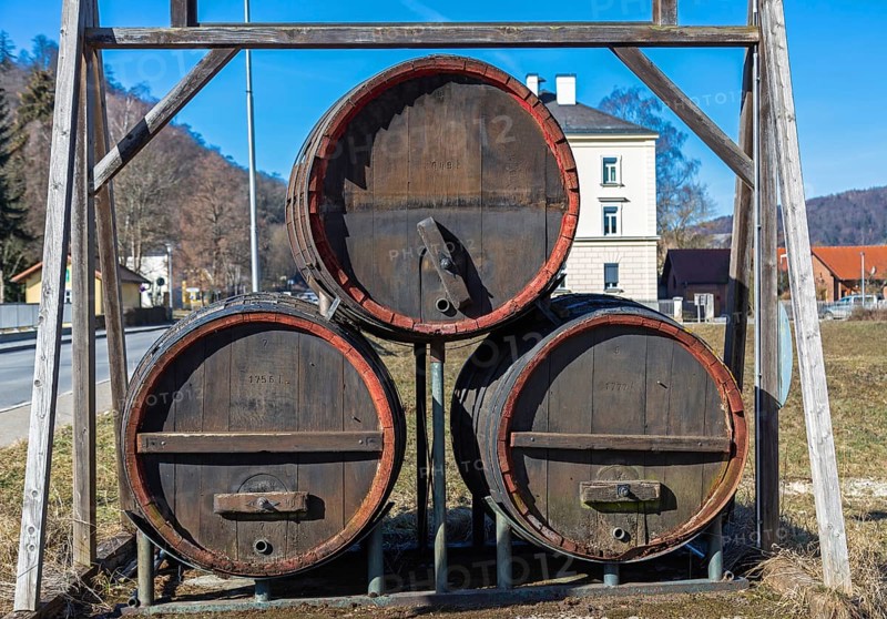 Three large old beer barrels on a road in Bavaria