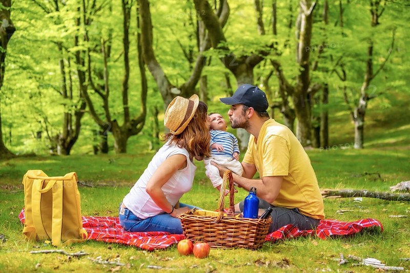 A picnic day with your newborn son. Dressed in white and yellow t-shirt, summer lifestyle of a family on vacation