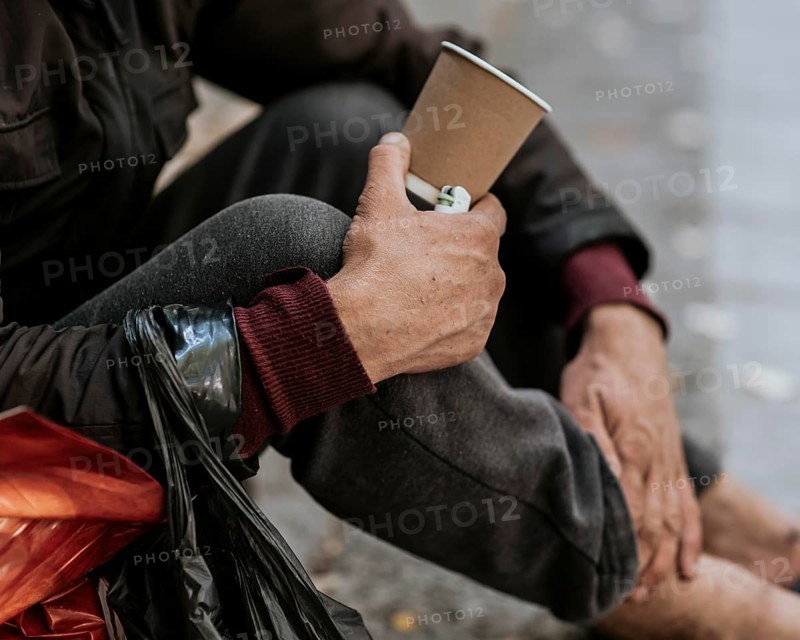 Side view homeless man holding cup