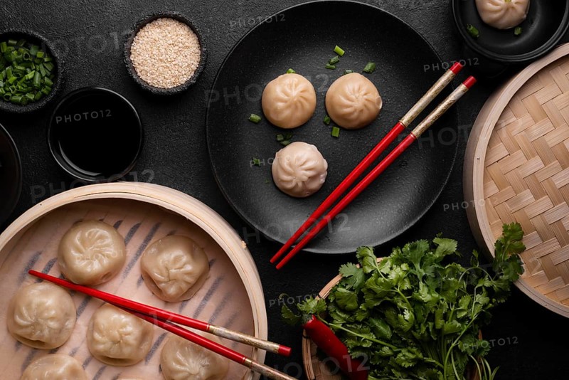 Top view asian dumplings with chopsticks herbs