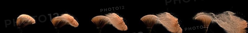 Make-up Brush spreading blush powder on black background