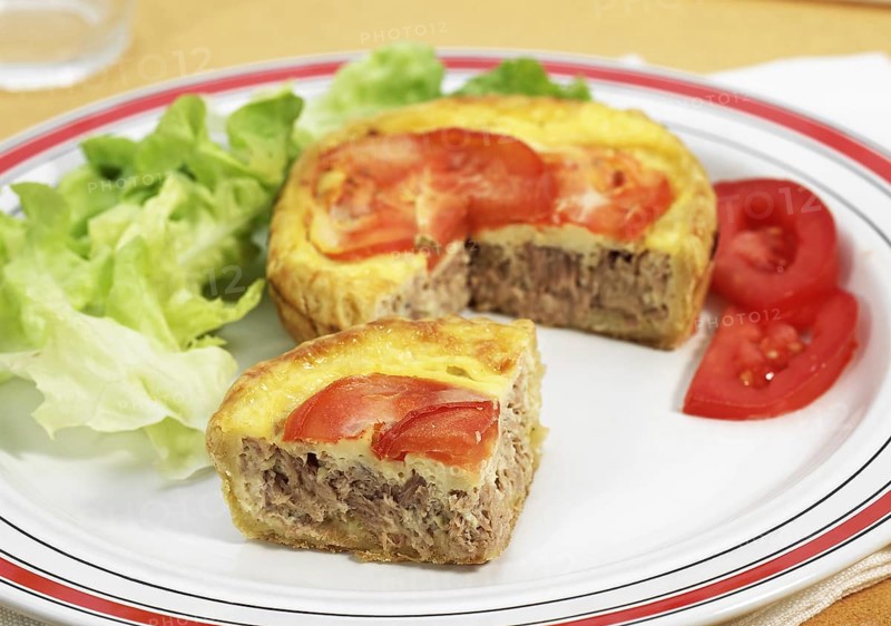 Tuna quiche with tomato and salad in plate