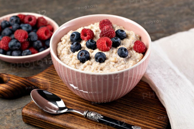 prepared oatmeal with berries on a wooden table