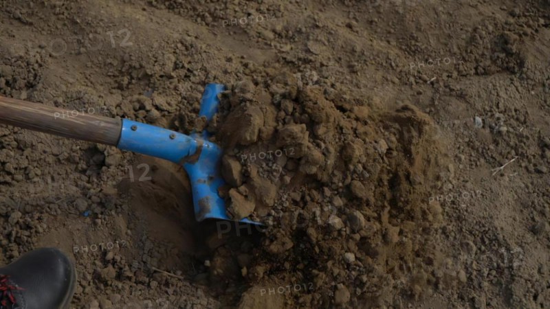 Shovel digging hole in the ground. Close up