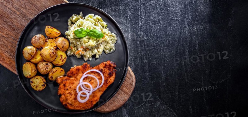 Chicken cutlet coated with breadcrumbs served with potatoes and cabbage
