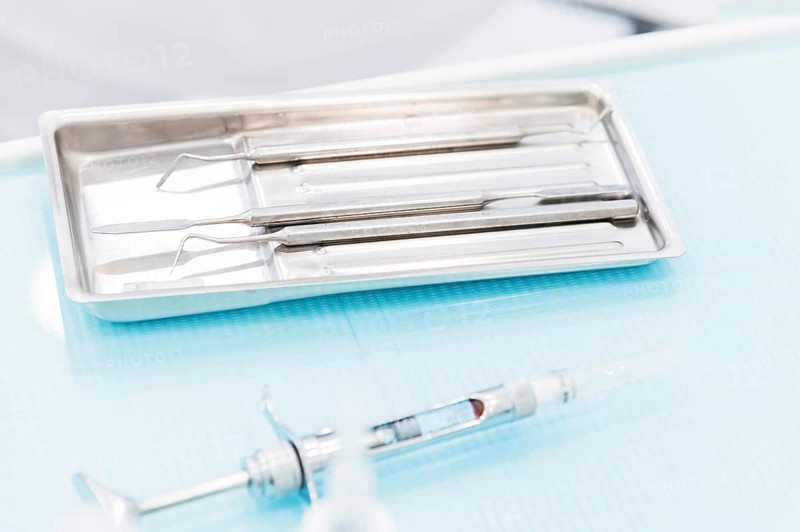 Close-up of a staminological instrument next to a metal syringe. Dental equipment. Dental hygiene and healthcare concept