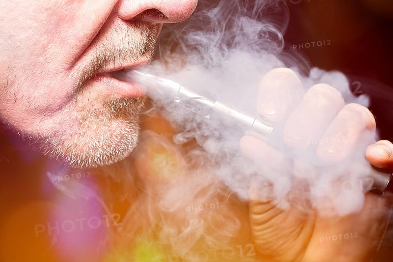 Close up portrait of a man smoking an e-cigarette