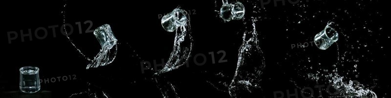 Glass of Water Bouncing and Splashing on Black Background