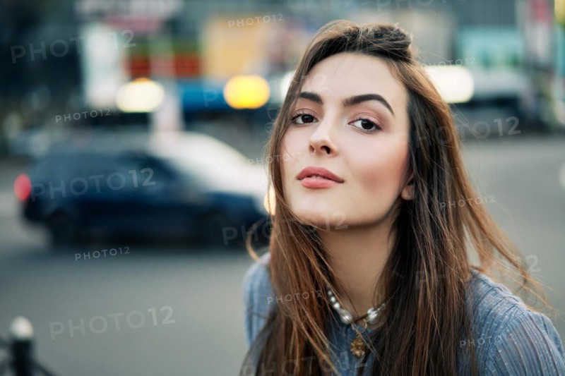 Close up young beautiful woman portrait posing in the city street in summer