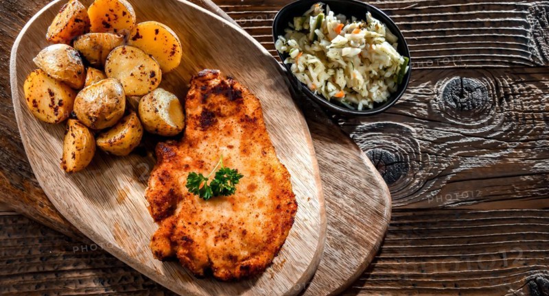 Chicken cutlet coated with breadcrumbs served with potatoes and cabbage