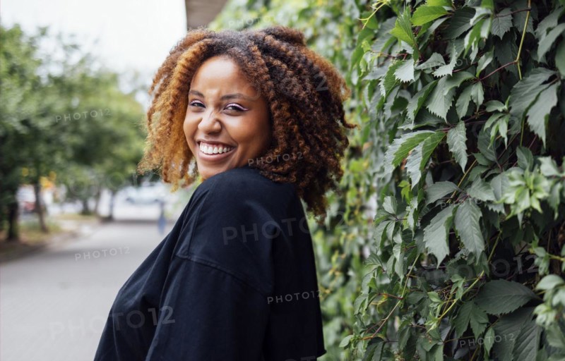 Close up photo of wavy hairdo charming cheerful dark skin person have good mood nice sightseeing weekend outdoors