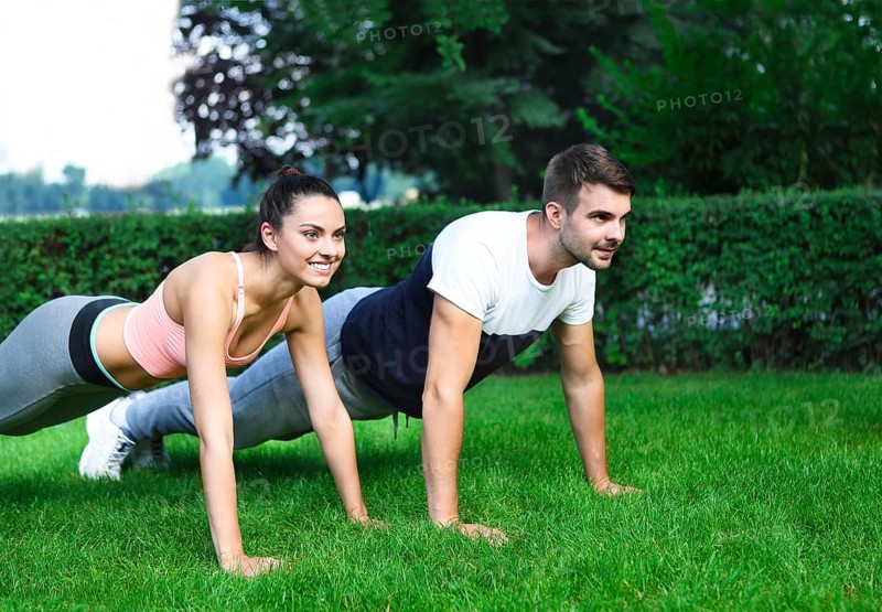 Young happpy couple exercising and stretching muscles before sport activity