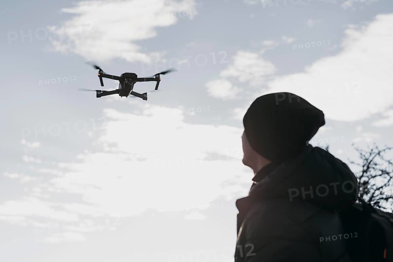 Low angle man watching drone