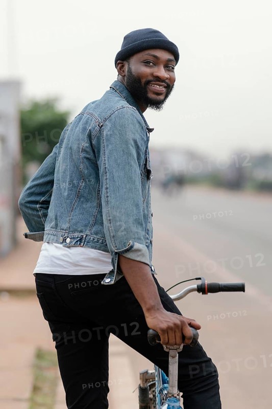 Medium shot man with bicycle posing