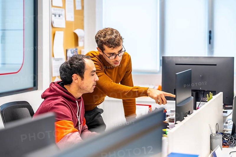 Team of engineers working with computer in a cnc modern factory office