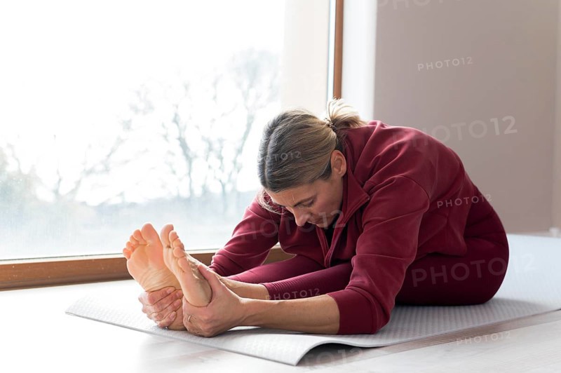 Mature woman doing sport exercises her window
