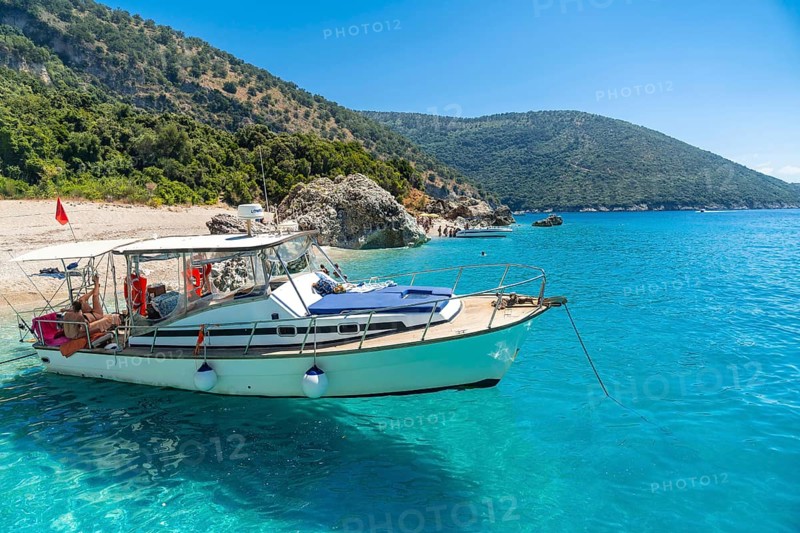 Boat in the transparent waters of the paradise beach of Kroreza or Krorez from the boat on the Albanian riviera in Sarande, Albania, Europe